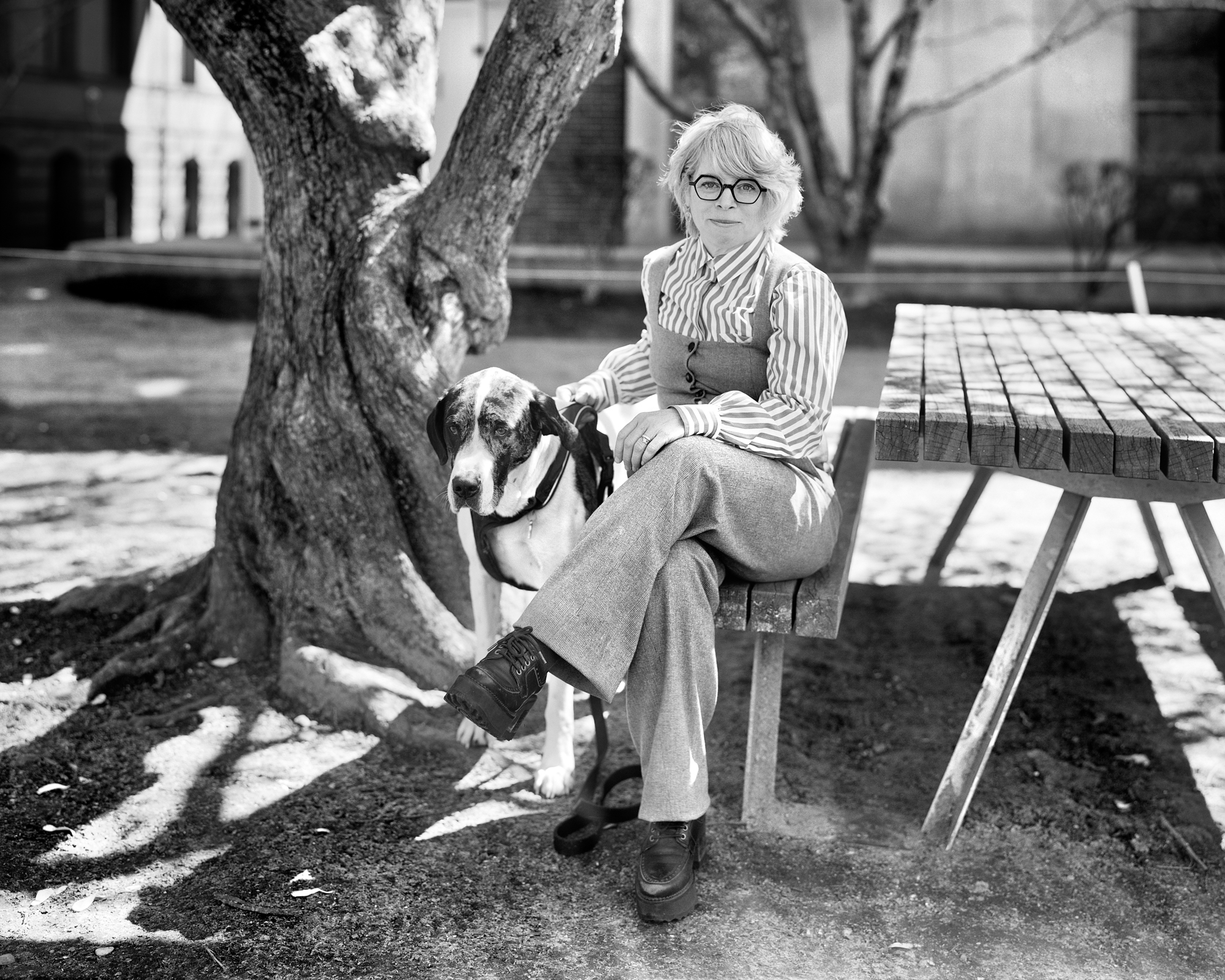 Jill Lepore sitting with her dog at a picnic table.